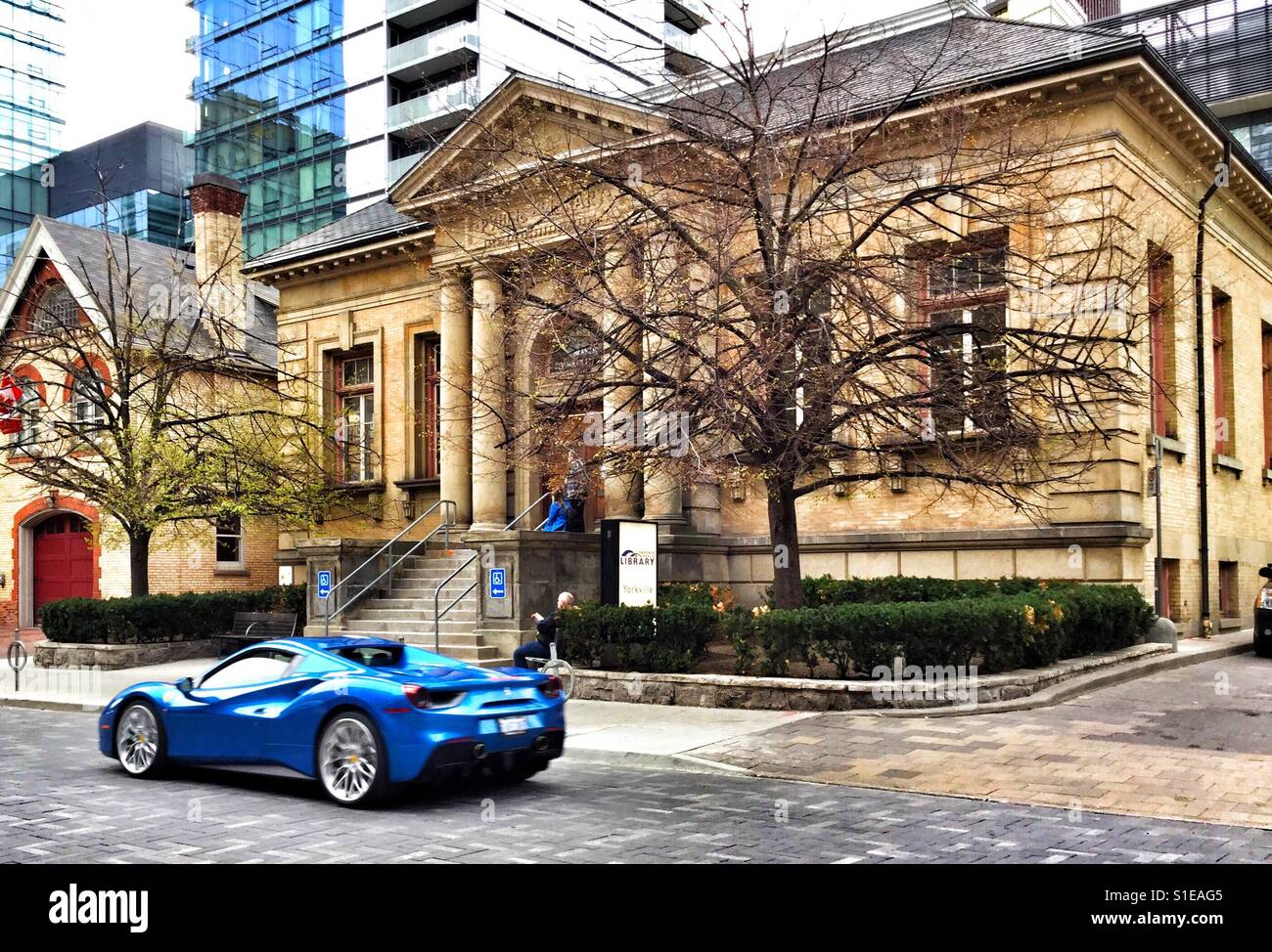 Blue luxury sports car in front of historical buildings in Yorkville neighbourhood. - Smartphone Captured Stock Image