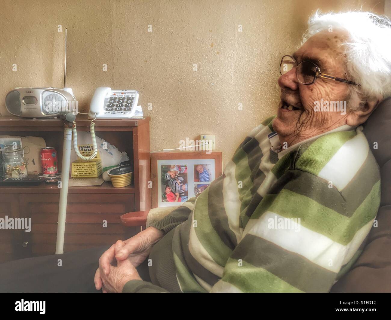Partially sighted elderly woman relaxing at home - Smartphone Captured Stock Image