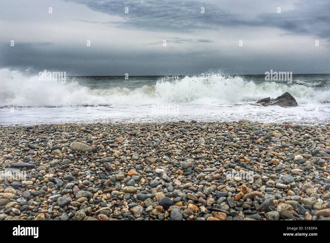 Breakers as tide comes in to a shingle beach on coast of Anglesey - Smartphone Captured Stock Image