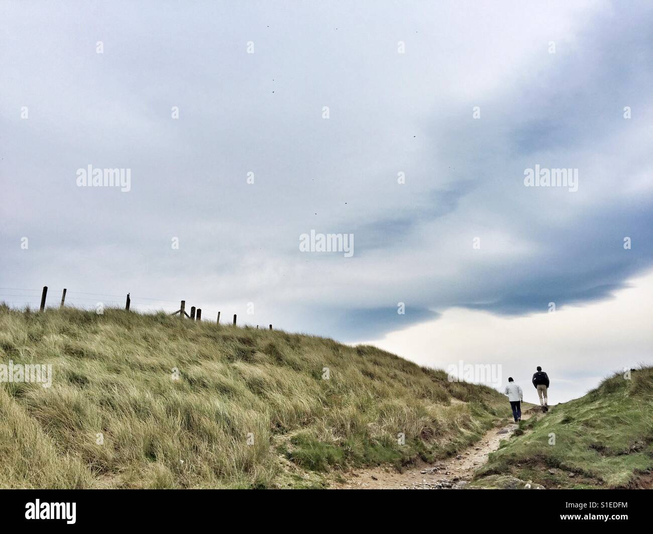 Walkers on the coastal path of Anglesey, near Rhosneigr Stock Photo