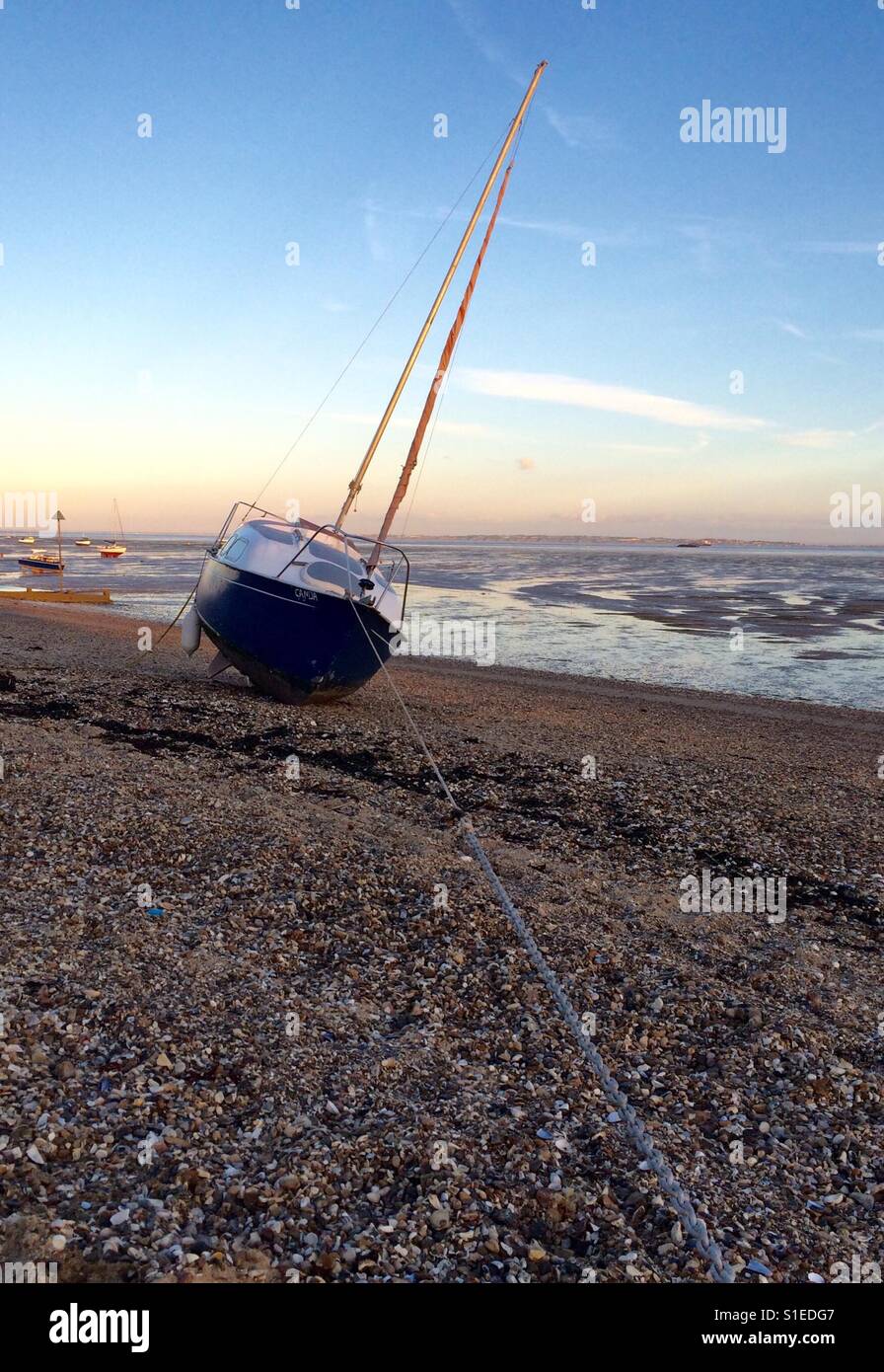 A beached sailing boat at low tide Stock Photo