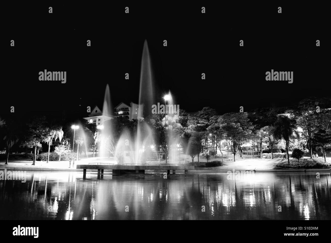 Illuminated fountain spraying water at night Stock Photo - Alamy