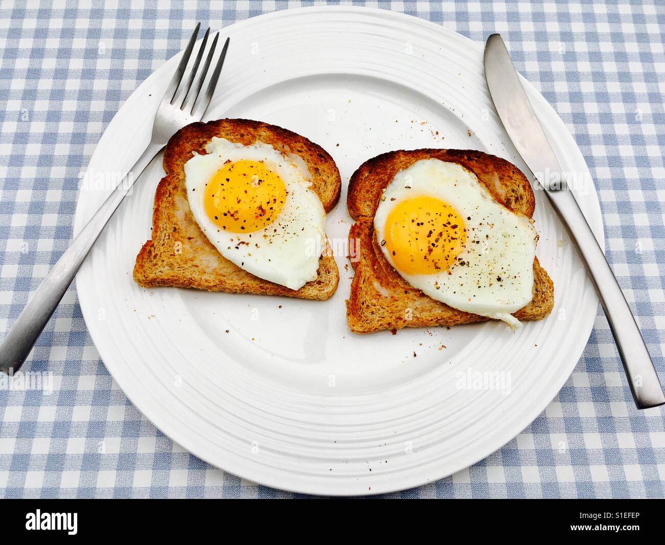 Fried eggs on toast with cracked black pepper Stock Photo Alamy