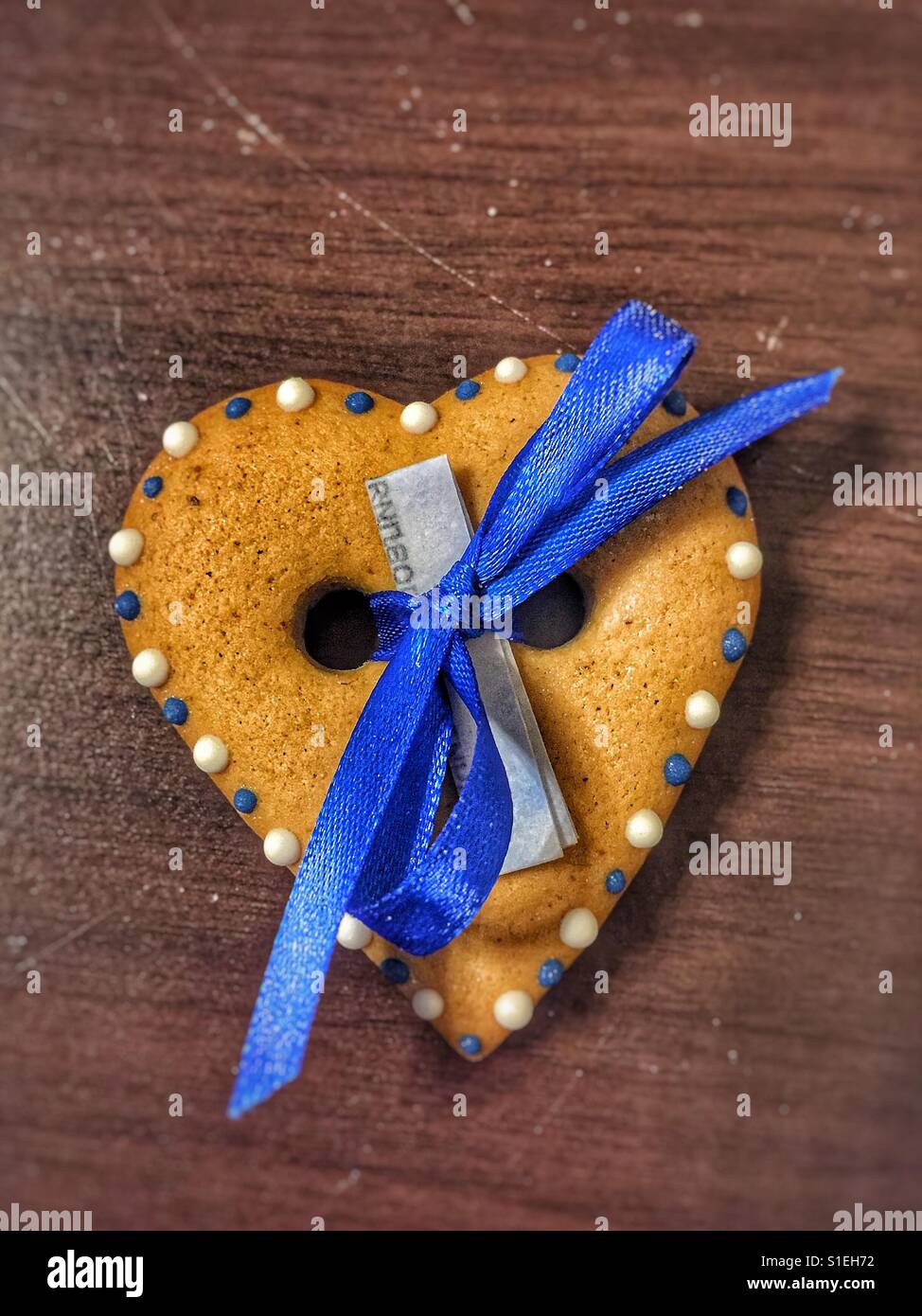 Heart shaped cookie with a blue ribbon and a wish note attached - Smartphone Captured Stock Image