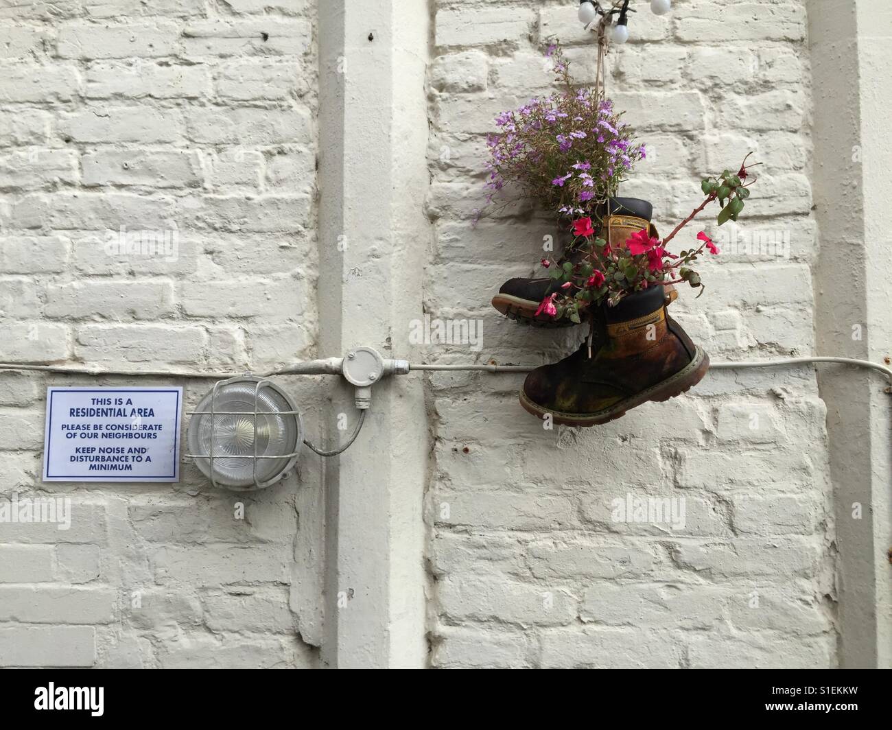 Boots on a wall Stock Photo - Alamy