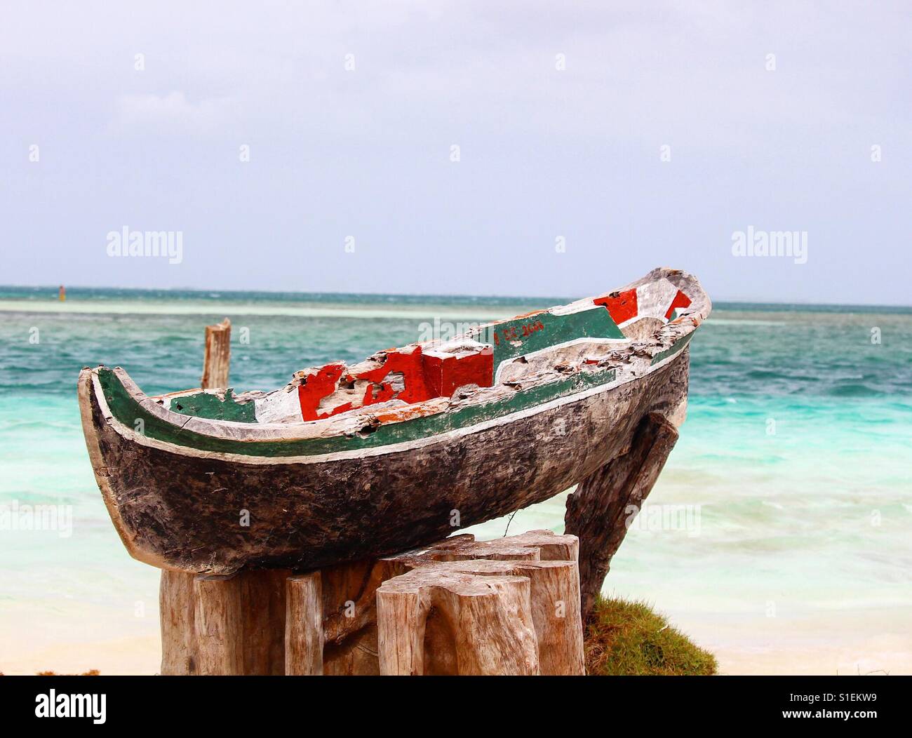 Rustic cayuco (dig out canoe) overlooking the Caribbean ocean. Stock Photo