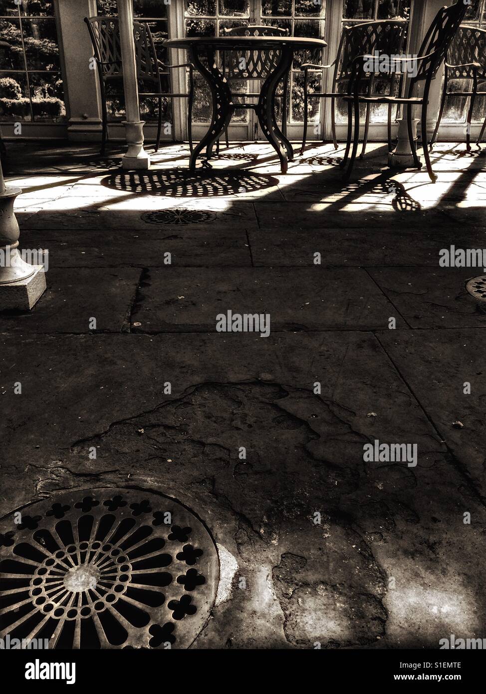 Stone floor, drainage and table and chairs in sunlight - Smartphone Captured Stock Image