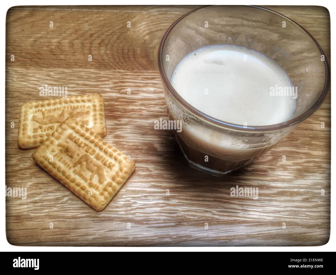 Warm milk with malted milk biscuits Stock Photo Alamy