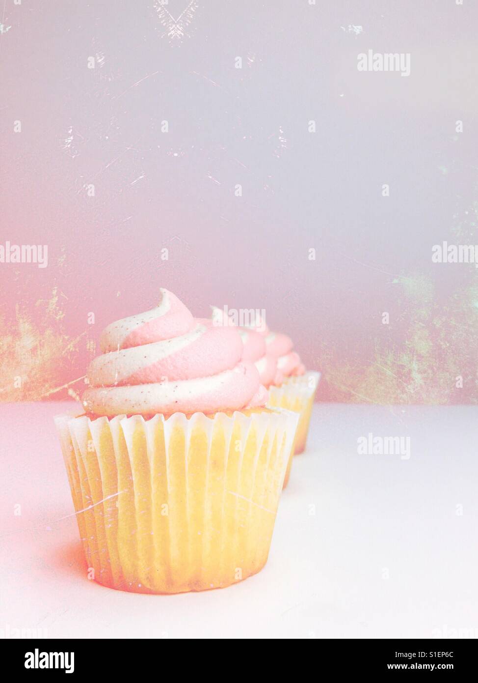 Vanilla cupcakes with strawberry vanilla frosting. Pastel edit. Space for copy. - Smartphone Captured Stock Image