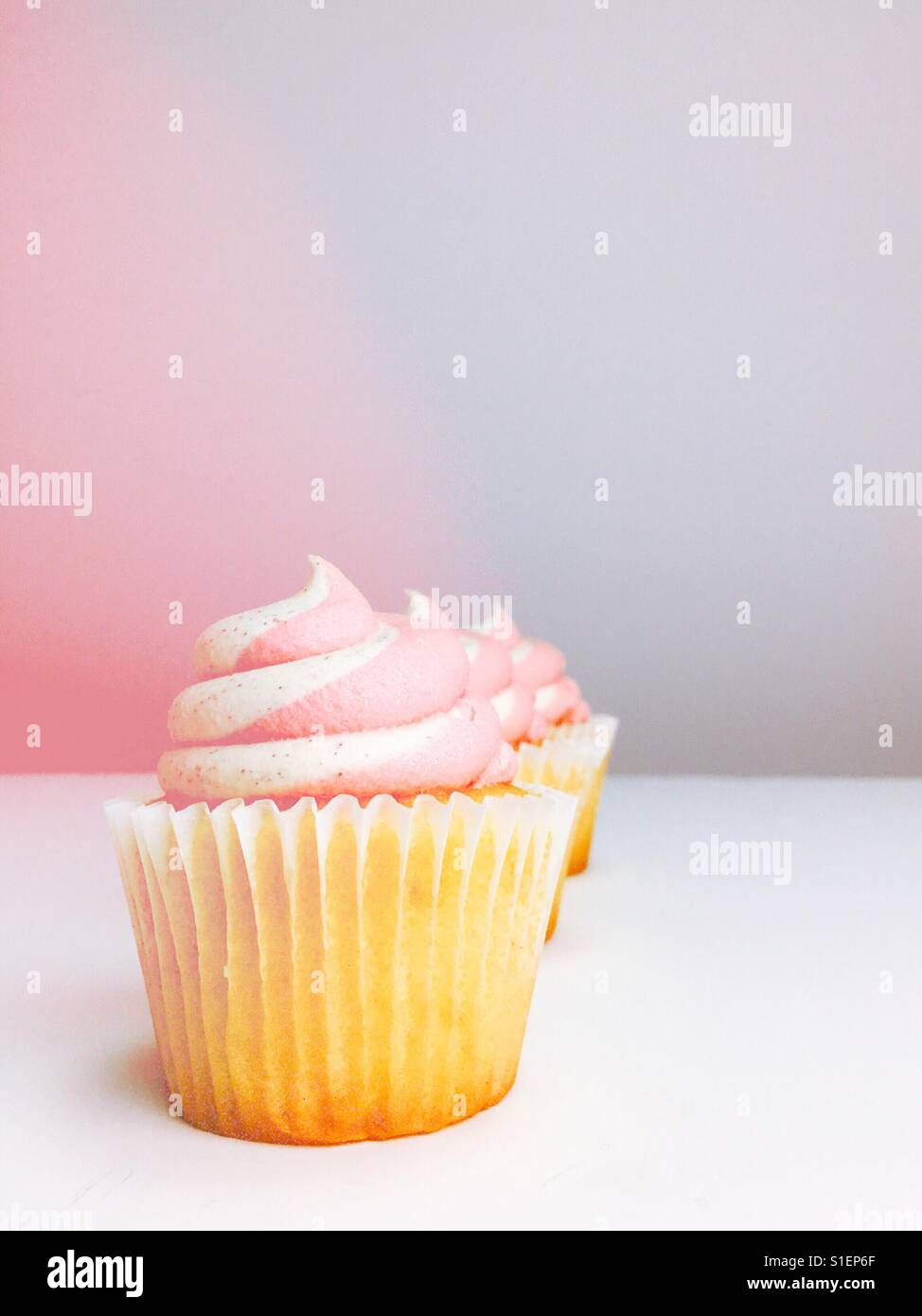 Vanilla cupcakes with strawberry vanilla frosting. Room for copy. - Smartphone Captured Stock Image