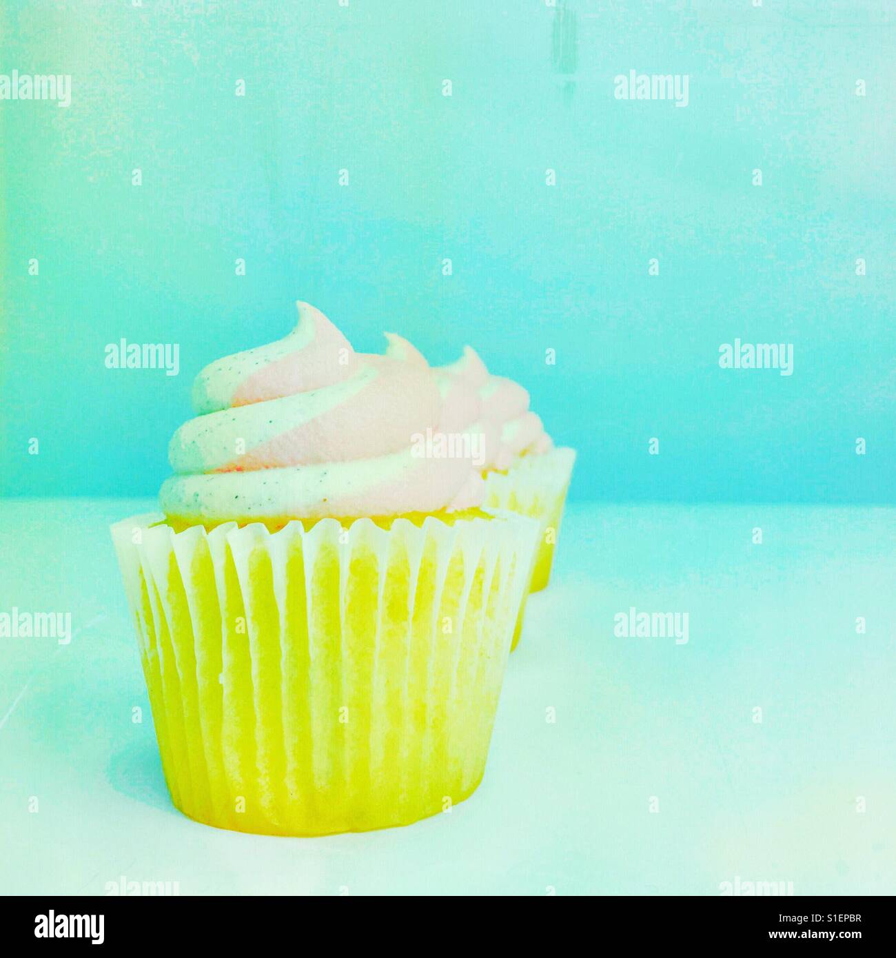 Cupcakes frosted with vanilla and strawberry buttercream. Pastel colours. Square crop. Space for copy. - Smartphone Captured Stock Image