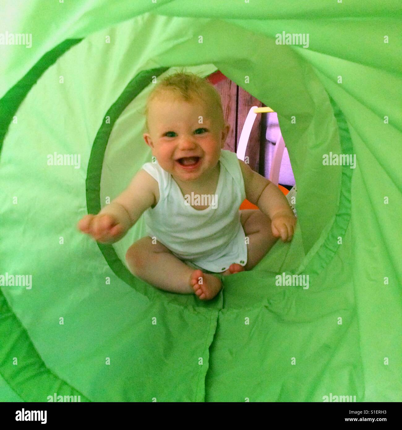 Eight month old baby boy playing in a tunnel - Smartphone Captured Stock Image