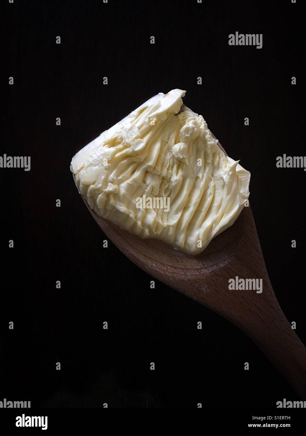 Butter on a wooden spoon' Stock Photo
