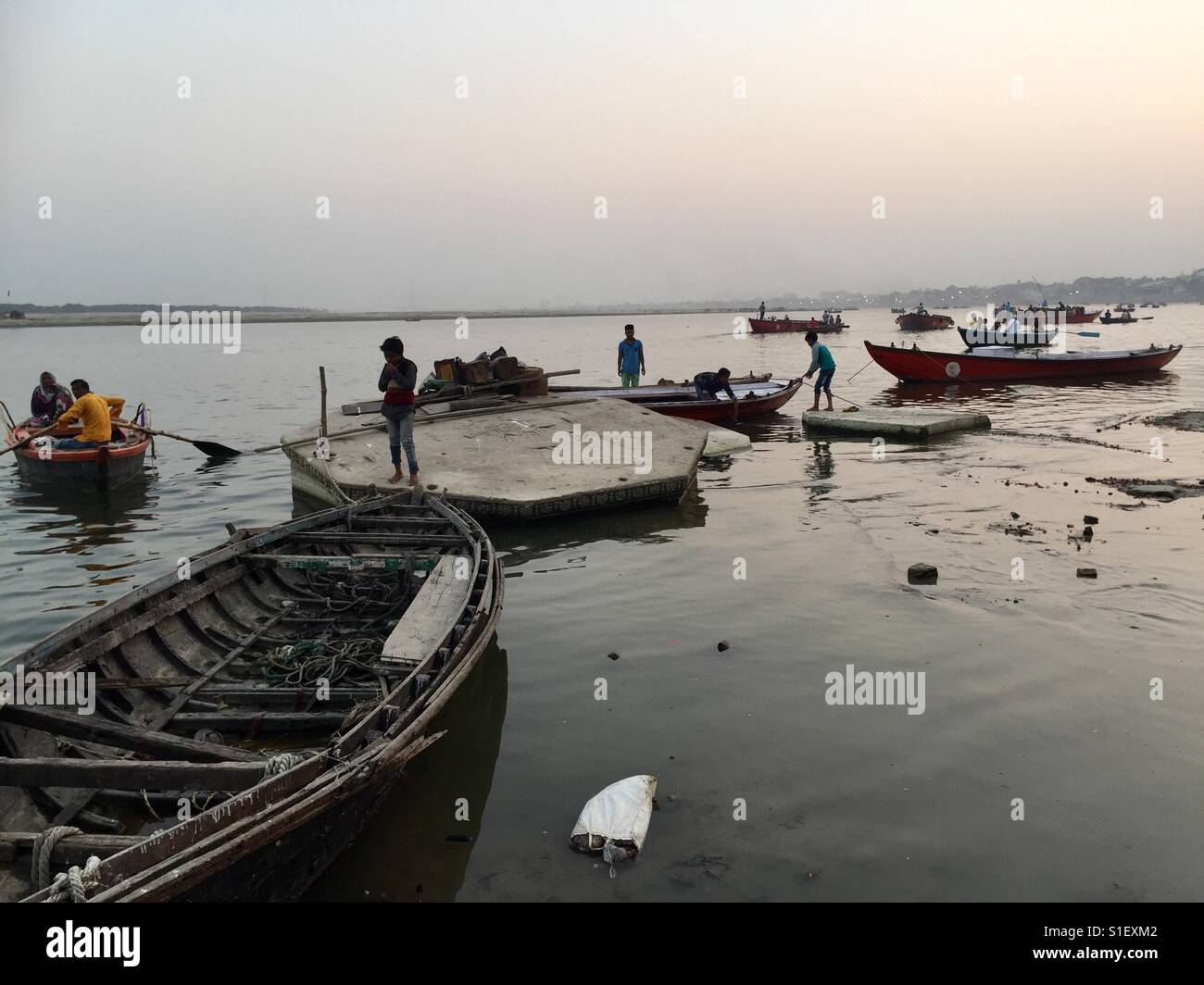 People are seen in boats along the river Ganges, Varanasi in India - Smartphone Captured Stock Image