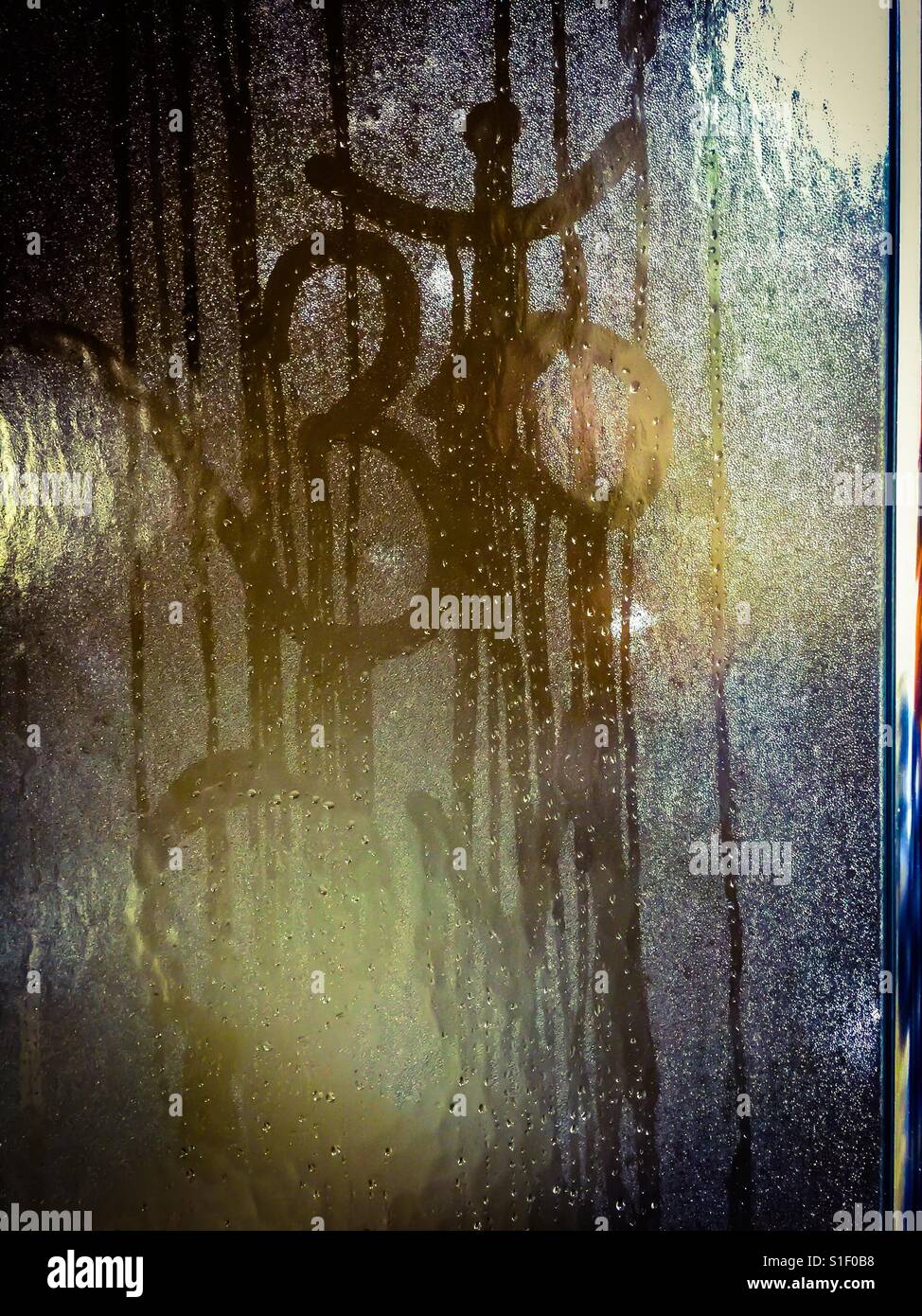 Steaming OM. The traditional iconic symbol hand-traced on a steamed glass door. The moving finger writes. Hindu. Sacred. Sign. - Smartphone Captured Stock Image