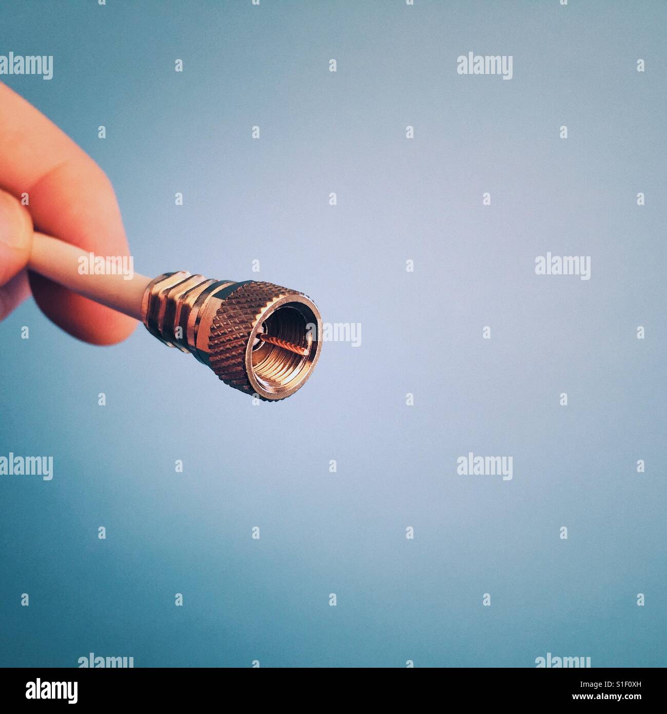 A man holding a coaxial television cable Stock Photo
