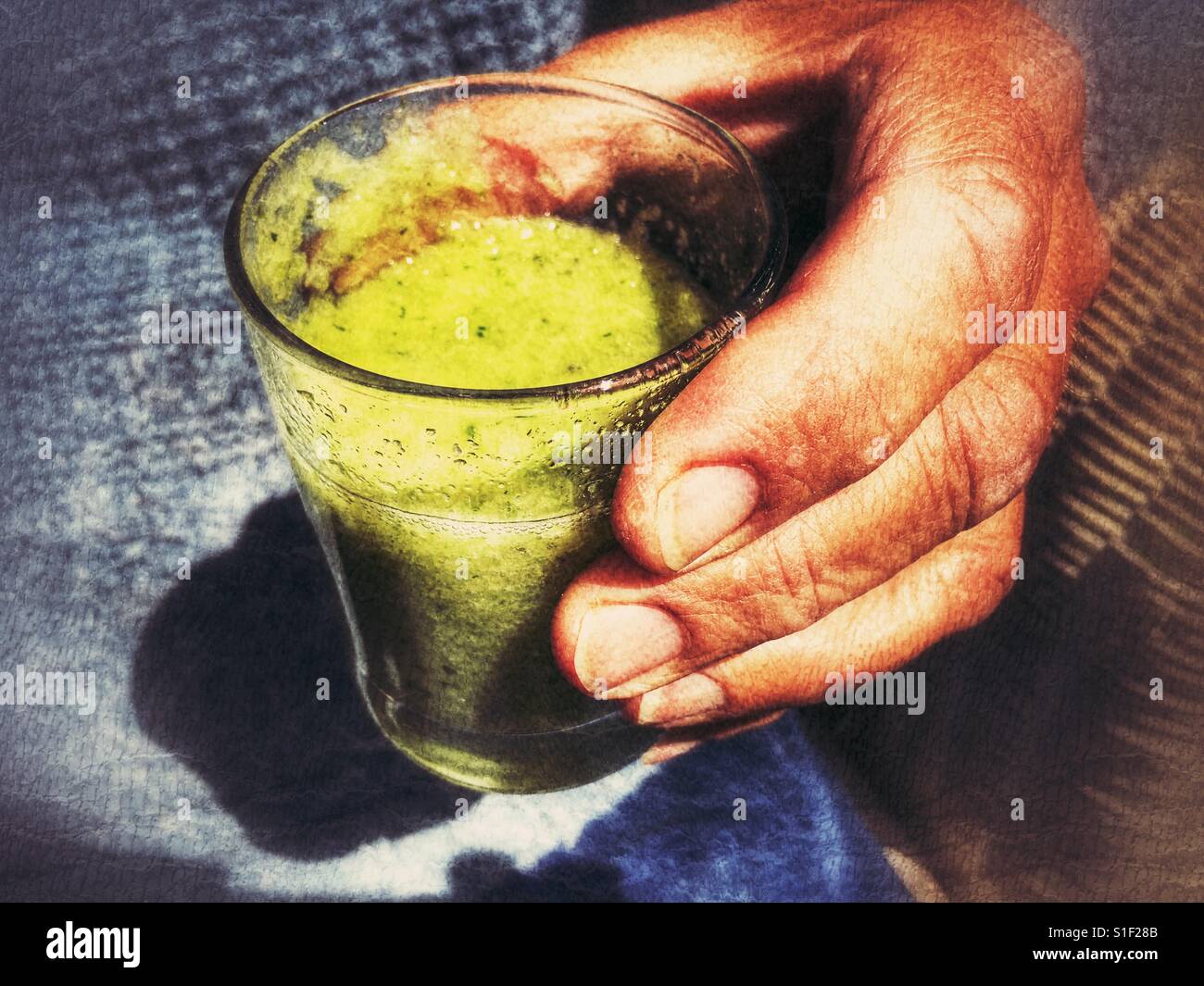 Green smoothie drink in a man's hand. - Smartphone Captured Stock Image