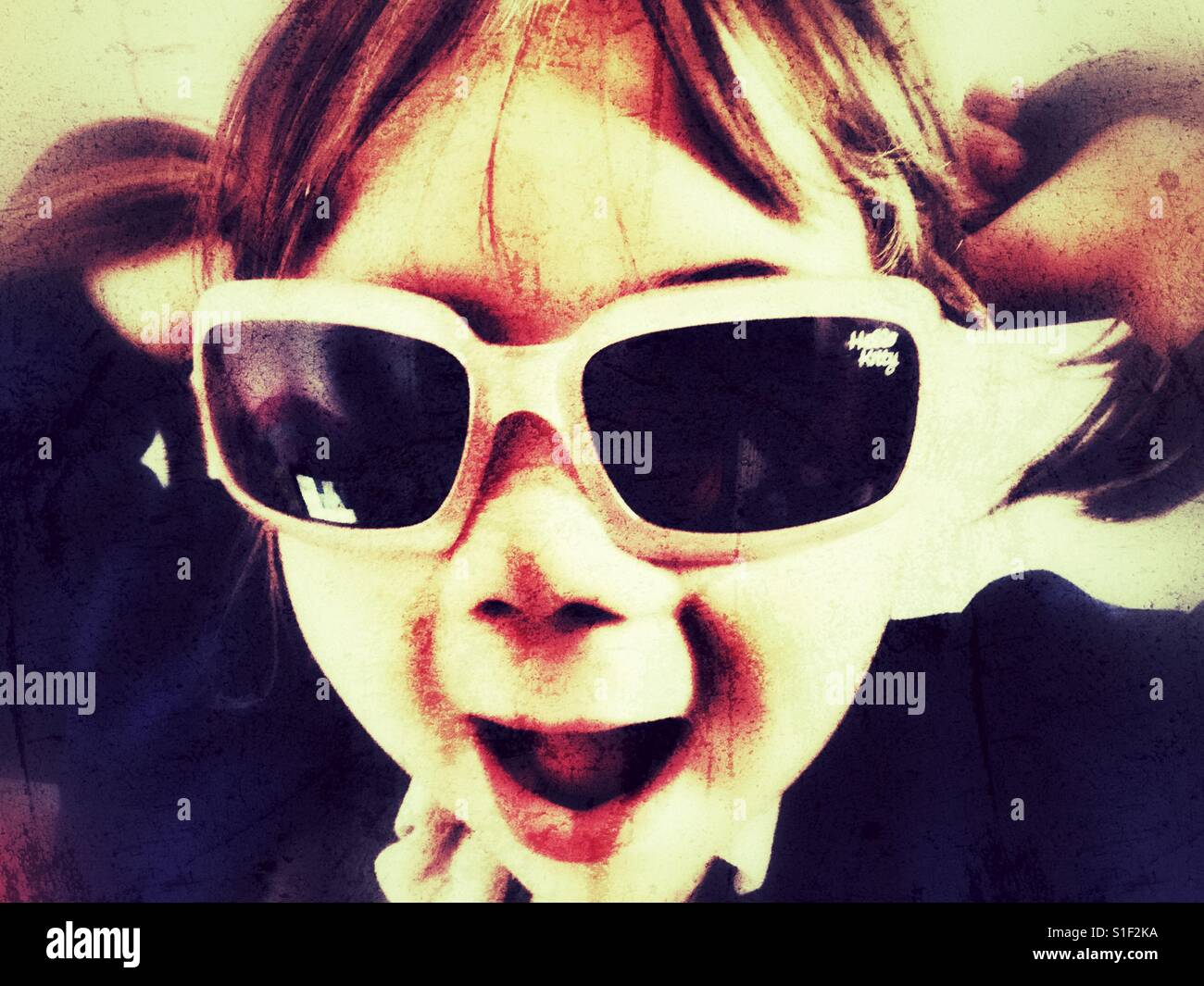 Grungy girl in sunglasses with pigtails Stock Photo