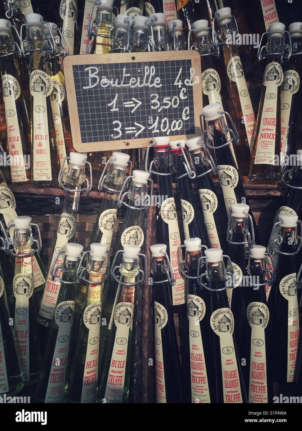 Bottles of vinegar for sale at Sarlat Market, Sarlat-la-Canéda in France - Smartphone Captured Stock Image