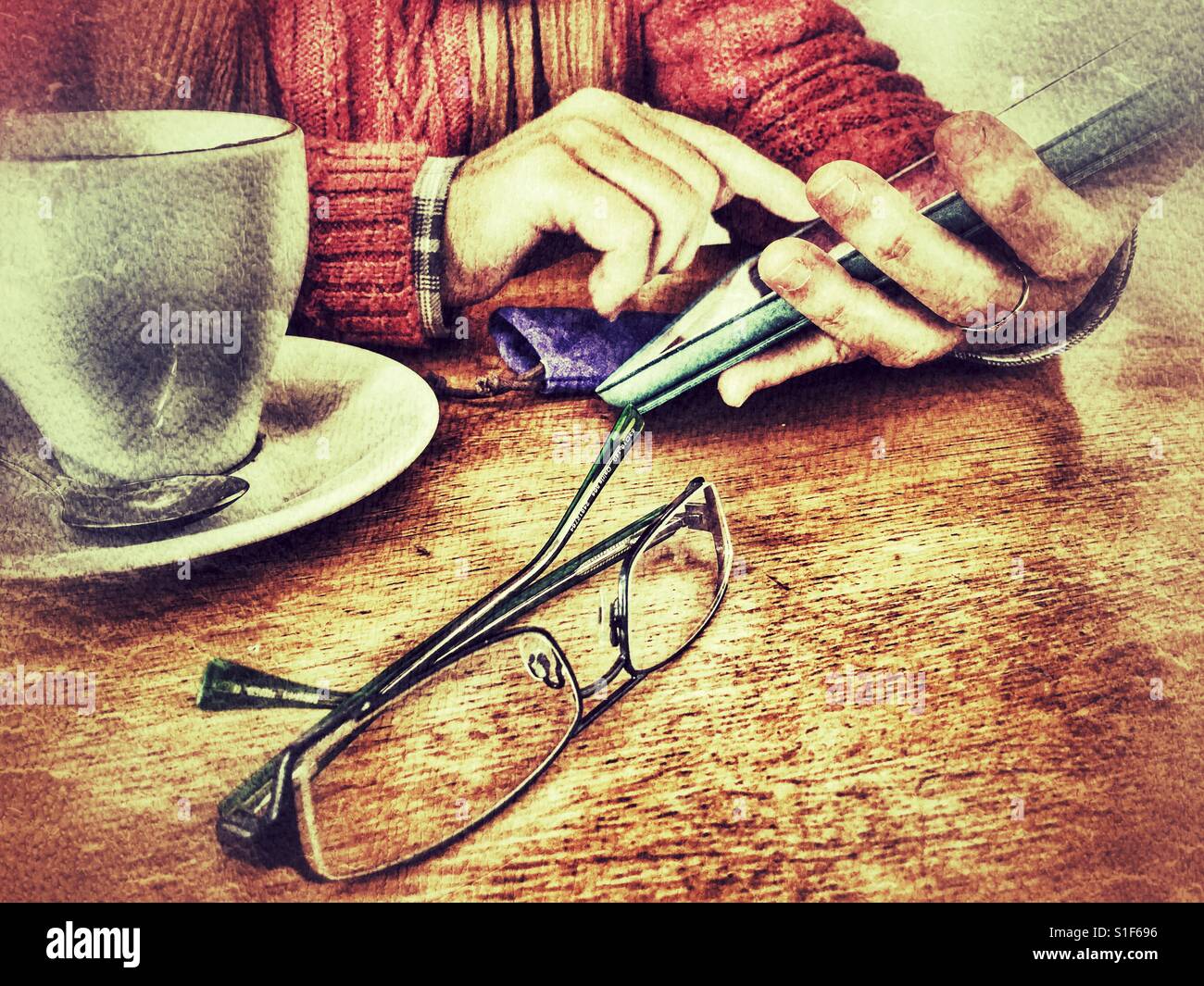 Woman using wireless technology , seated at a table with a hot drink - Smartphone Captured Stock Image