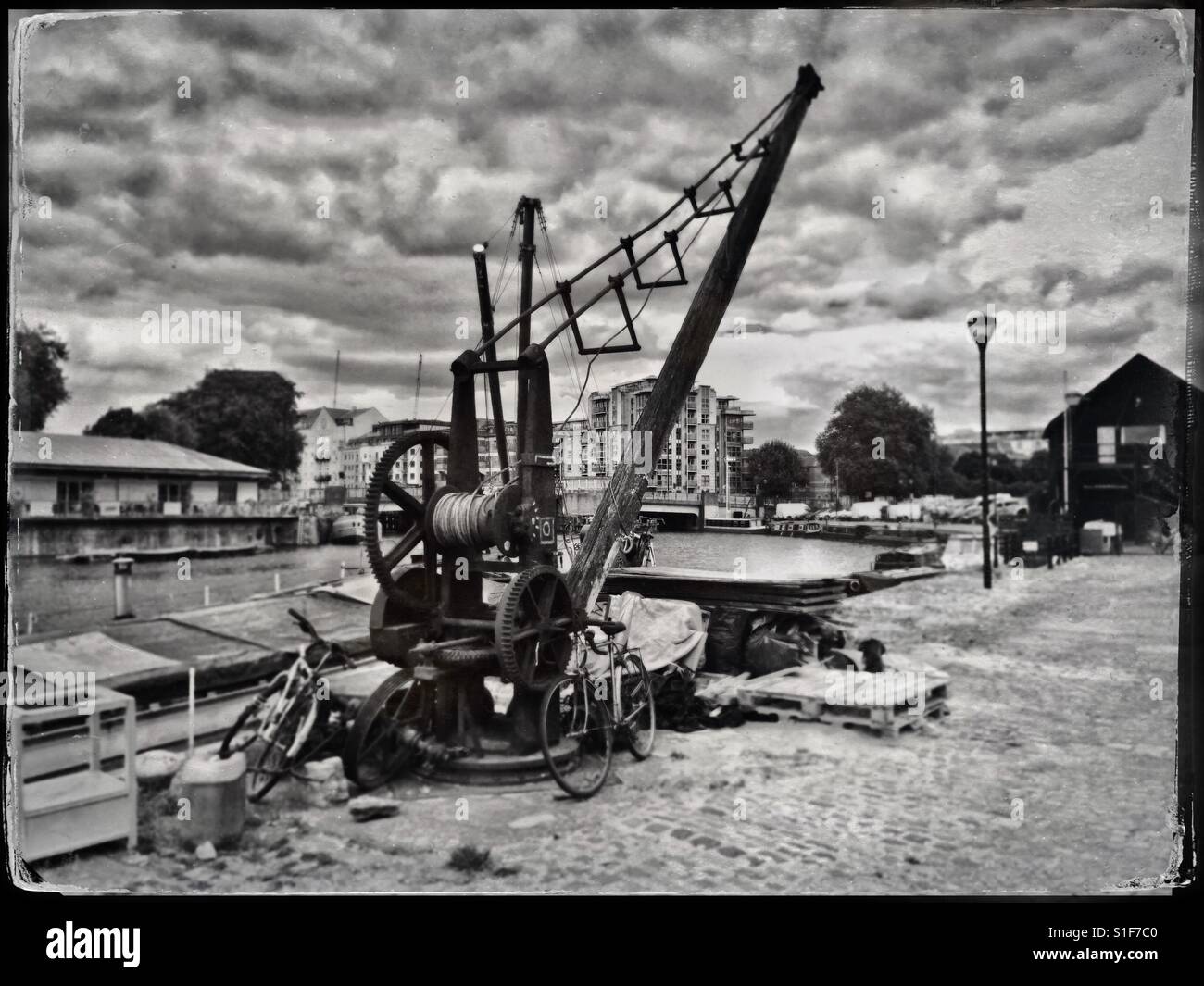 A simulated tintype photograph of a hand-operated wooden crane in the city docks in Bristol, UK Stock Photo