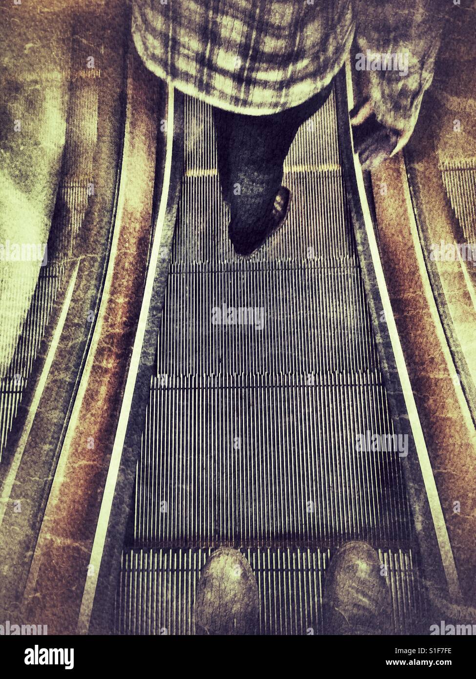 POV brown leather boots on a moving escalator, with another person lower down - Smartphone Captured Stock Image