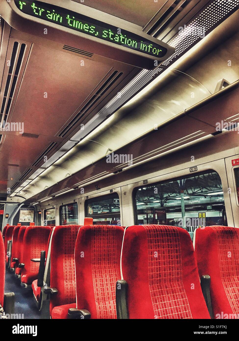 Digital display in an empty train compartment at night. - Smartphone Captured Stock Image