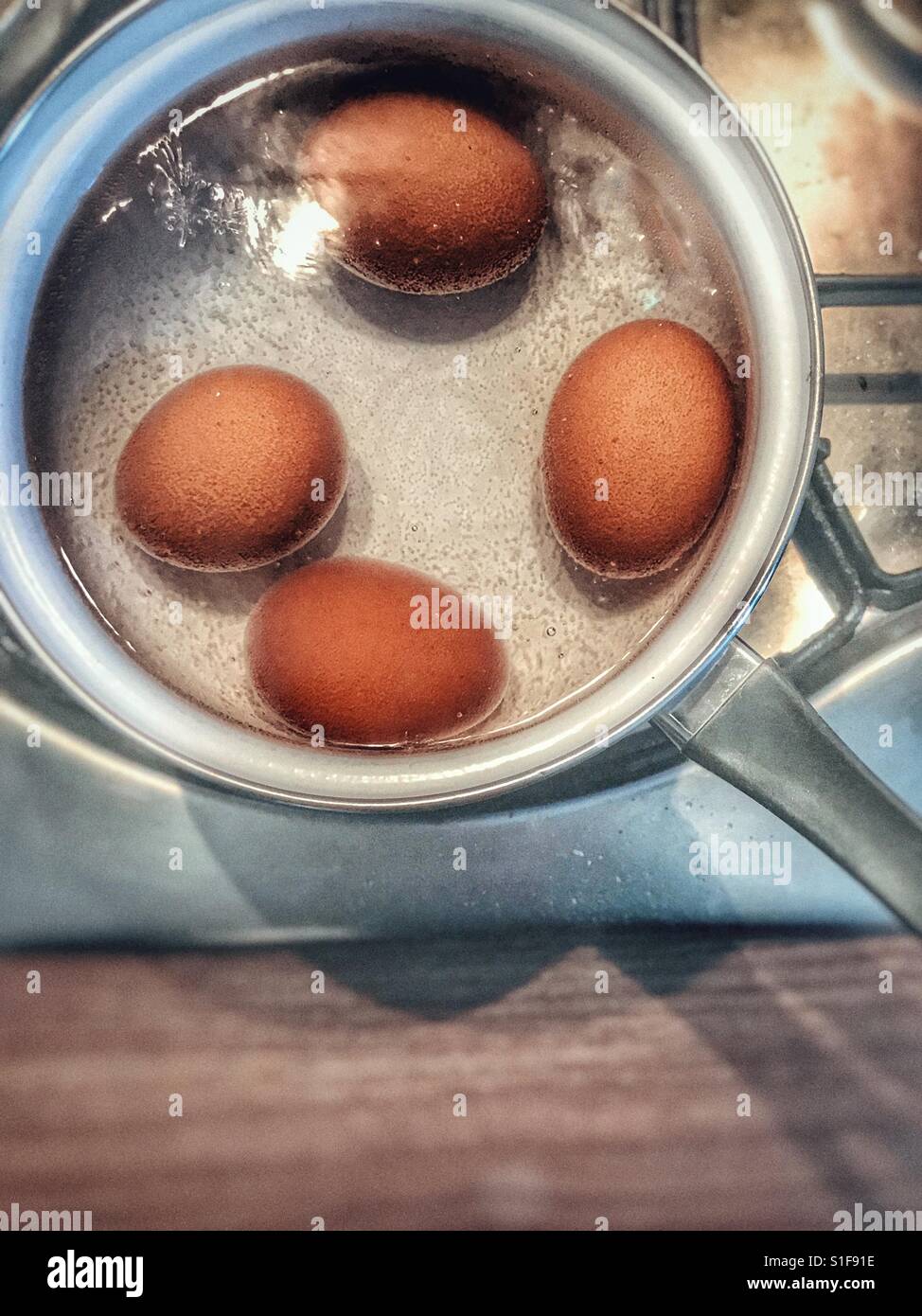 Boiling four eggs Stock Photo