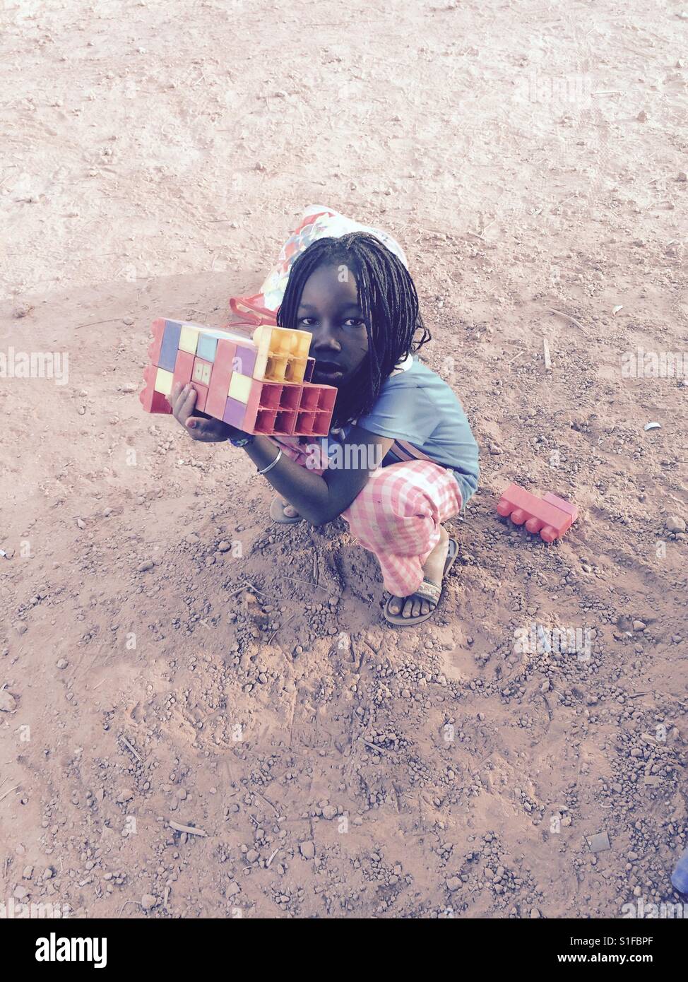 A child plays with legos in Burkina Faso, Africa. Stock Photo