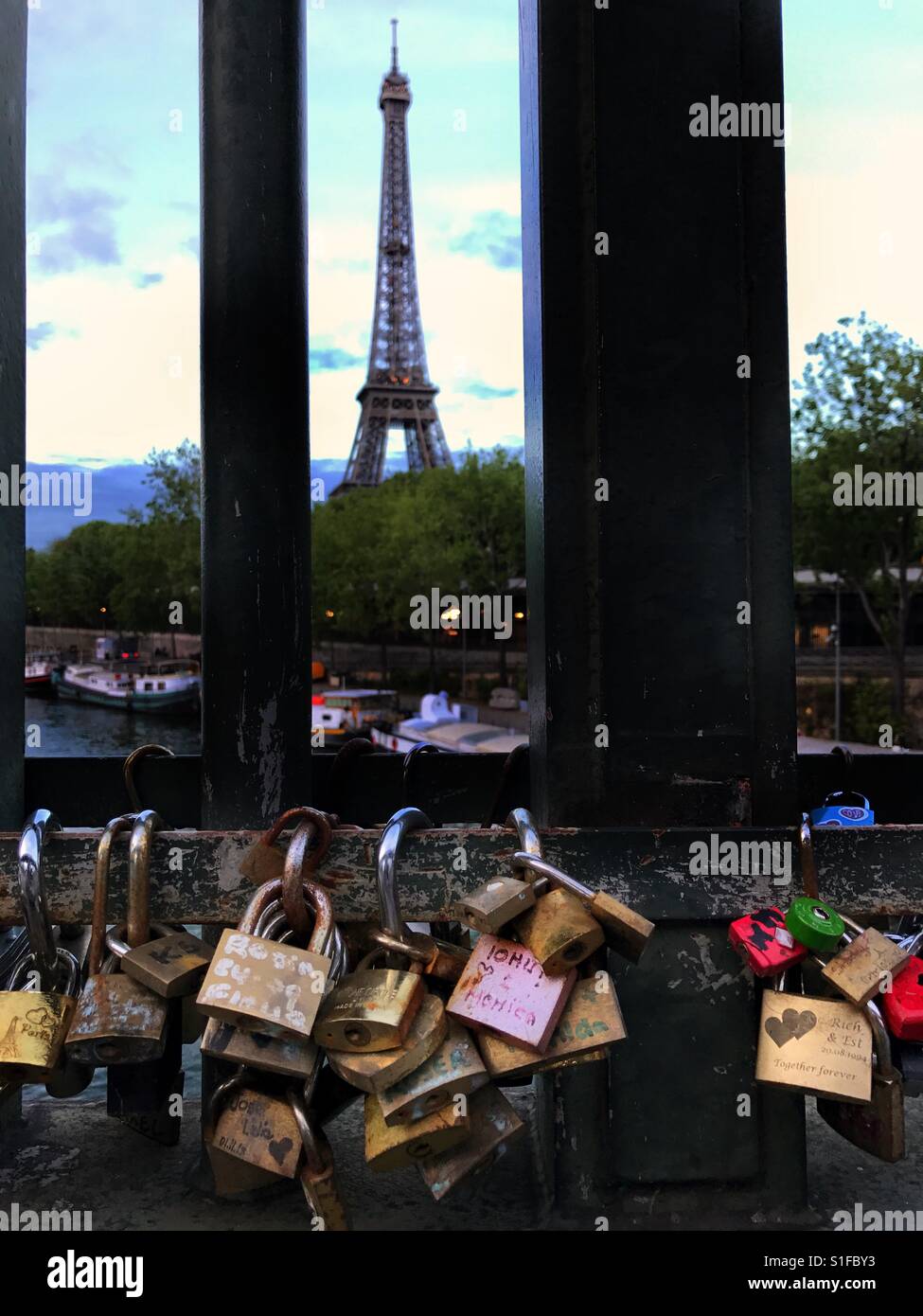 Locked love..lockers of various size,shape,and design adorn the fences and bridges of Paris especially the area surrounding the Eiffel Tower - Smartphone Captured Stock Image