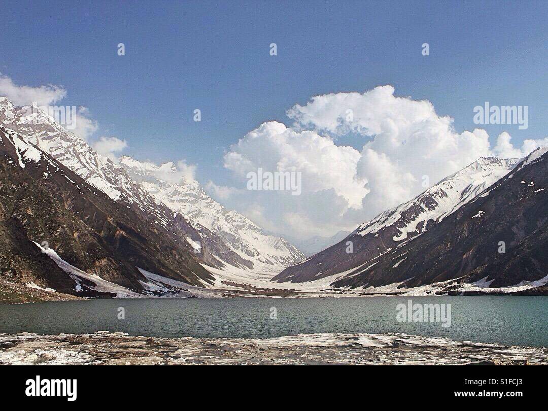 A lake surrounded by mountains covered in snow Stock Photo