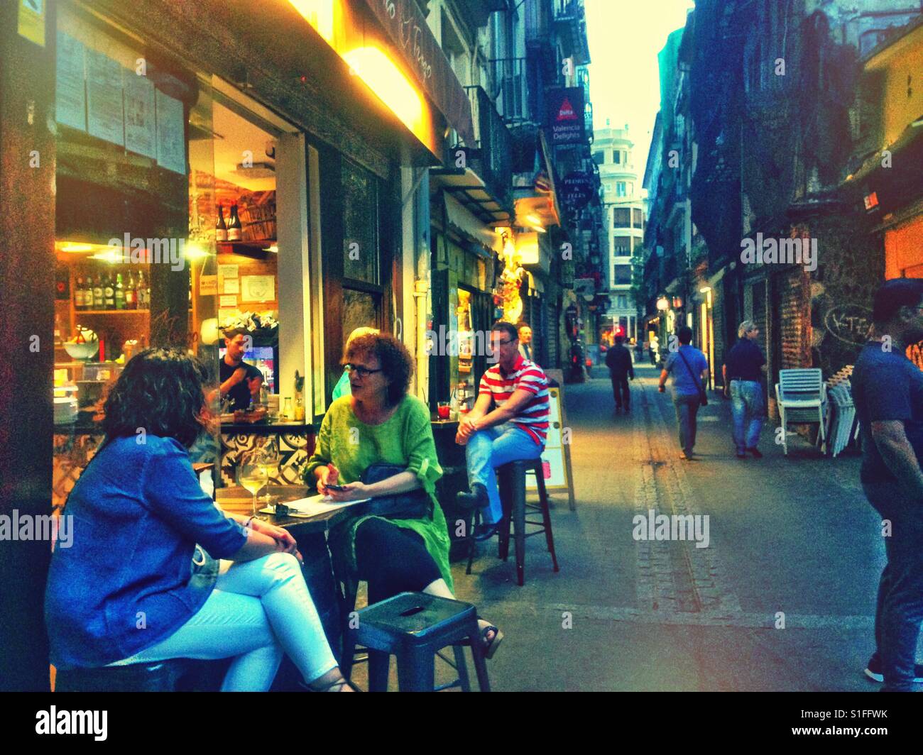 People sitting outside a cafe in Valencia. - Smartphone Captured Stock Image