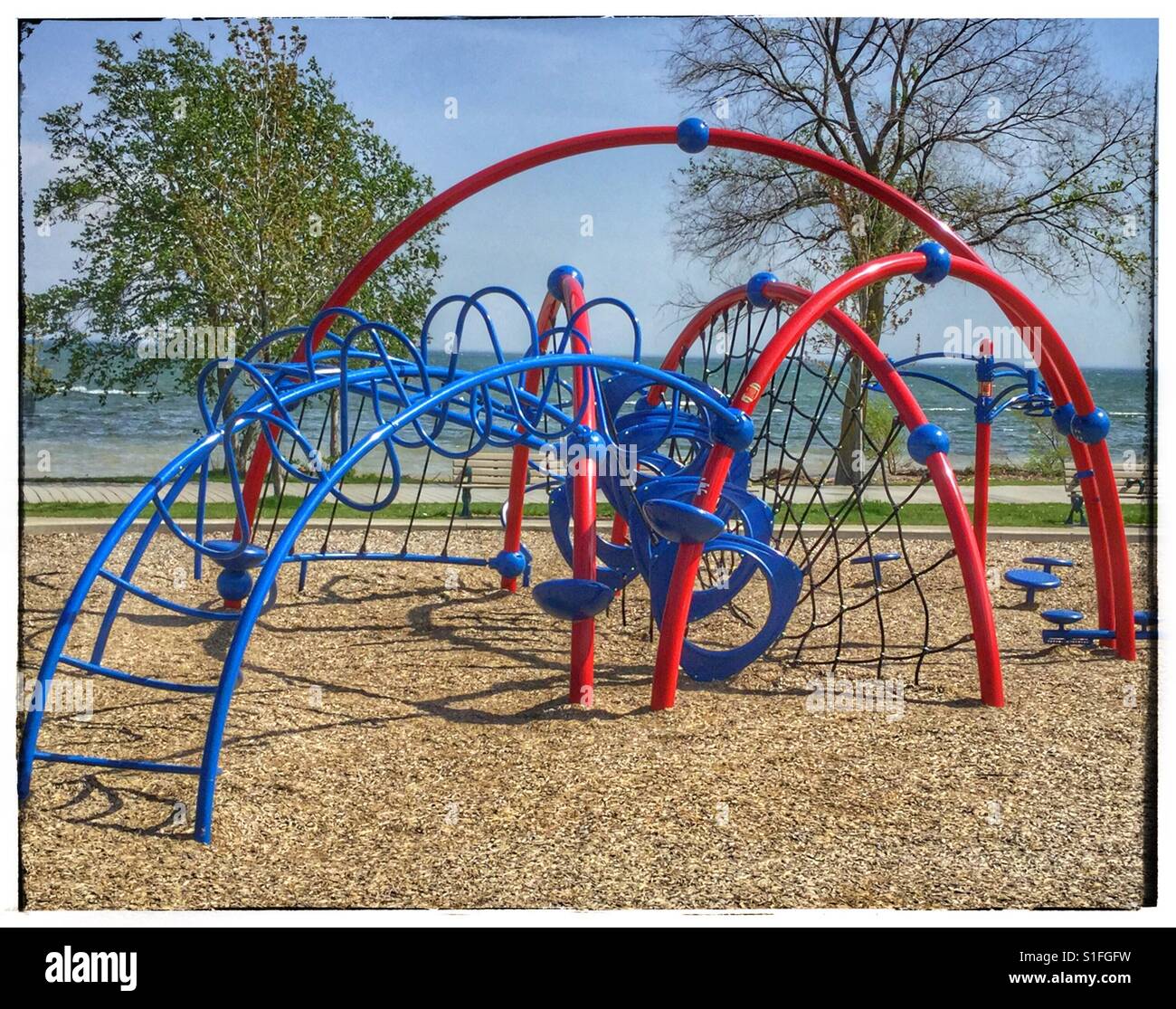 Climbing apparatus in playground by the lake. Stock Photo