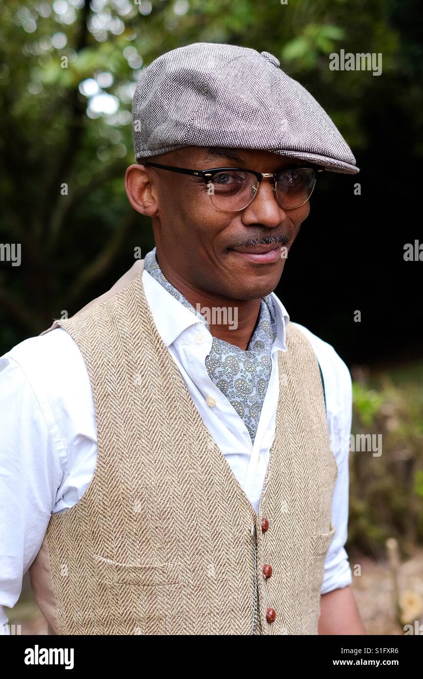 Young black man dressed in vintage clothing with a cravat , flat cap and waistcoat. Stock Photo