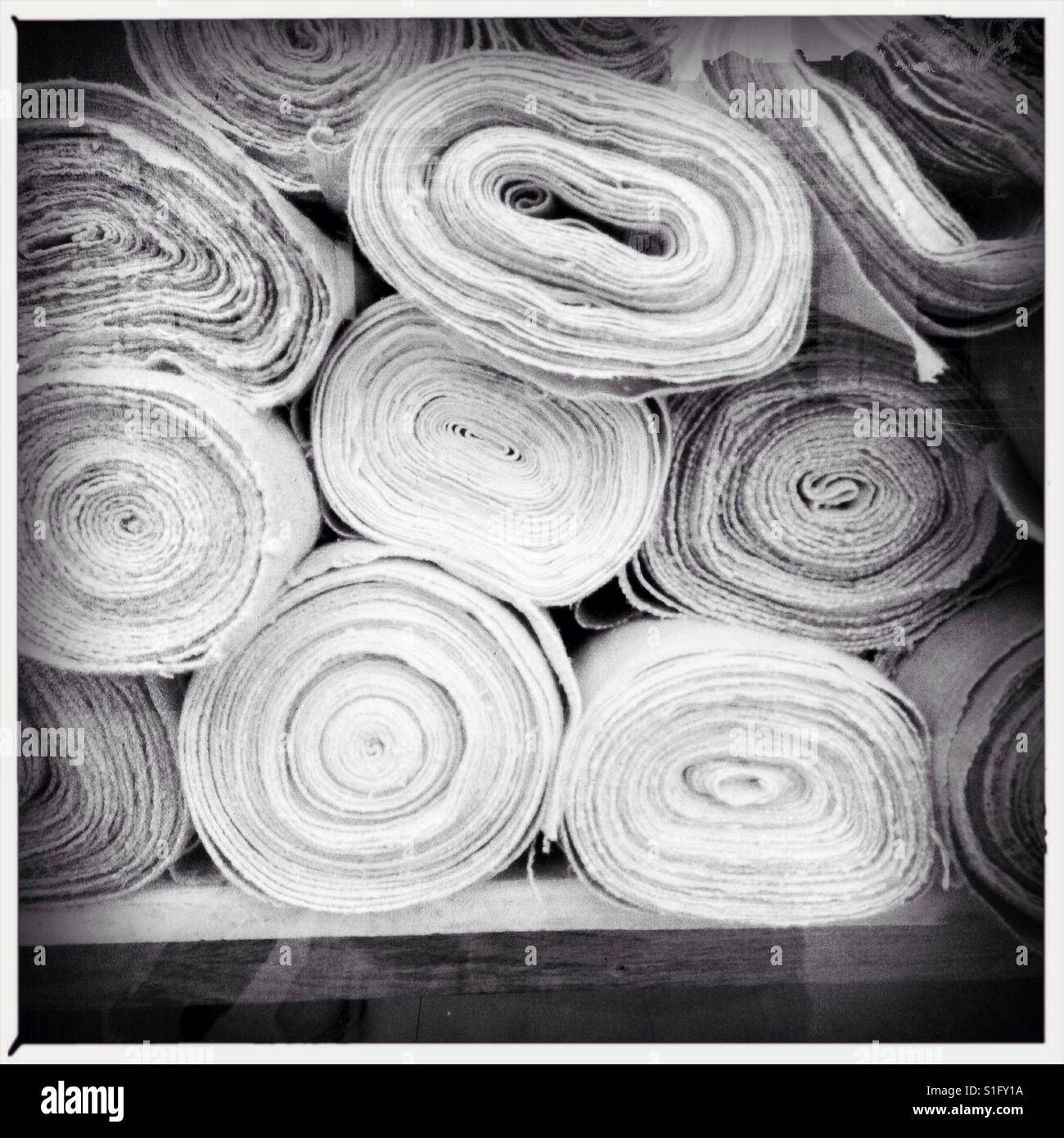 side view of rolls of antique fabric rolled on a pile Stock Photo