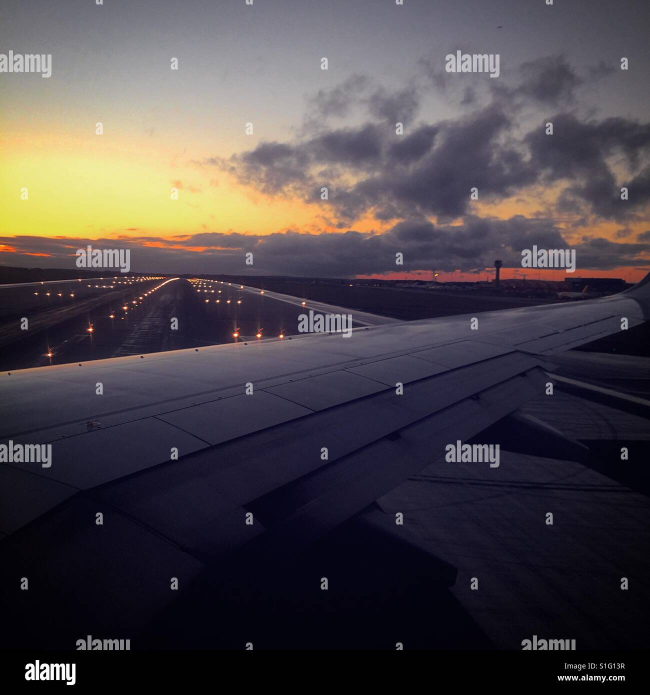 View from airplane before take off with colourful sky during sunset in the background. - Smartphone Captured Stock Image