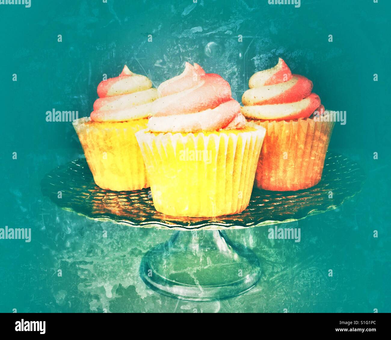 Buttercream frosted cupcakes on a glass serving platter. Stock Photo