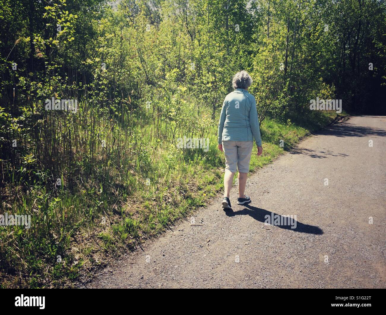 Woman walking on path Stock Photo