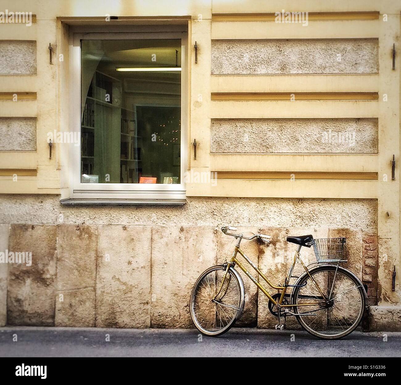 Lady's Bicycle with basket standing against the wall of a house next to a window , Vienna, Austria Stock Photo