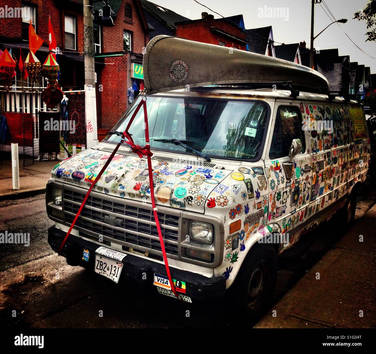 White van full of decals and canoe on roof. - Smartphone Captured Stock Image
