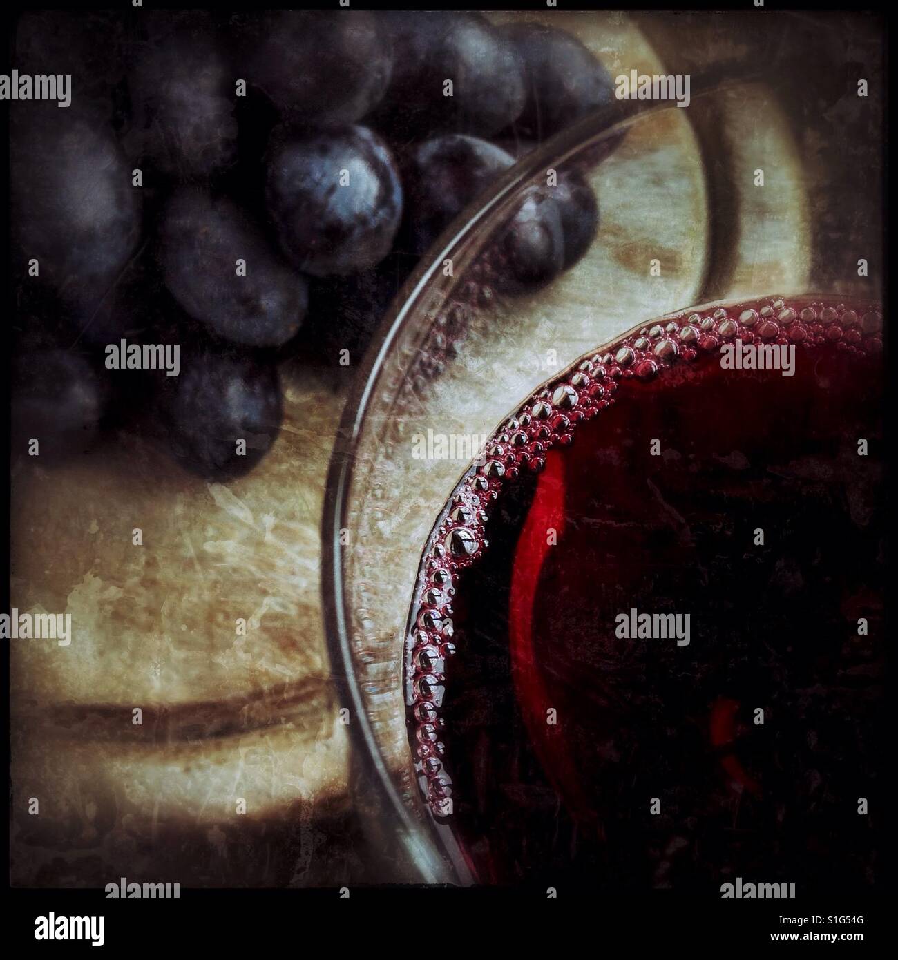 A glass of red wine with some 'Autumn Royal' table [eating] grapes on a wooden board. - Smartphone Captured Stock Image