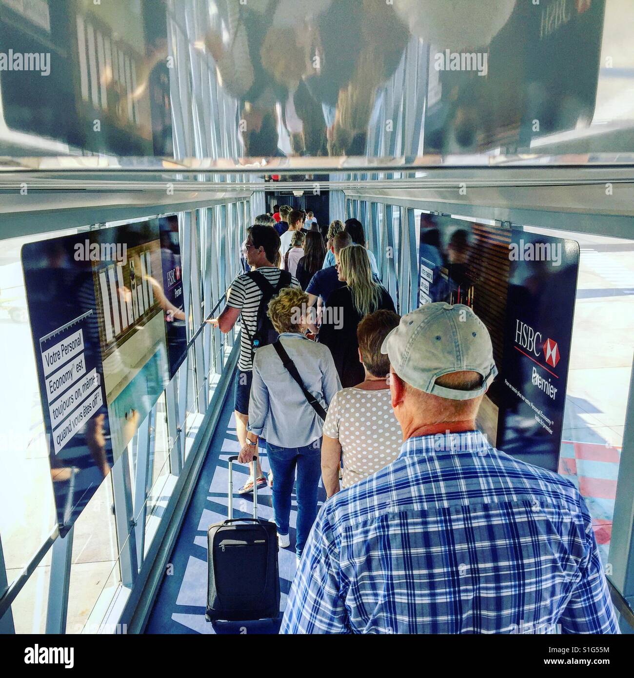 People queue in an air-jetty to board an aircraft and an airport - Smartphone Captured Stock Image