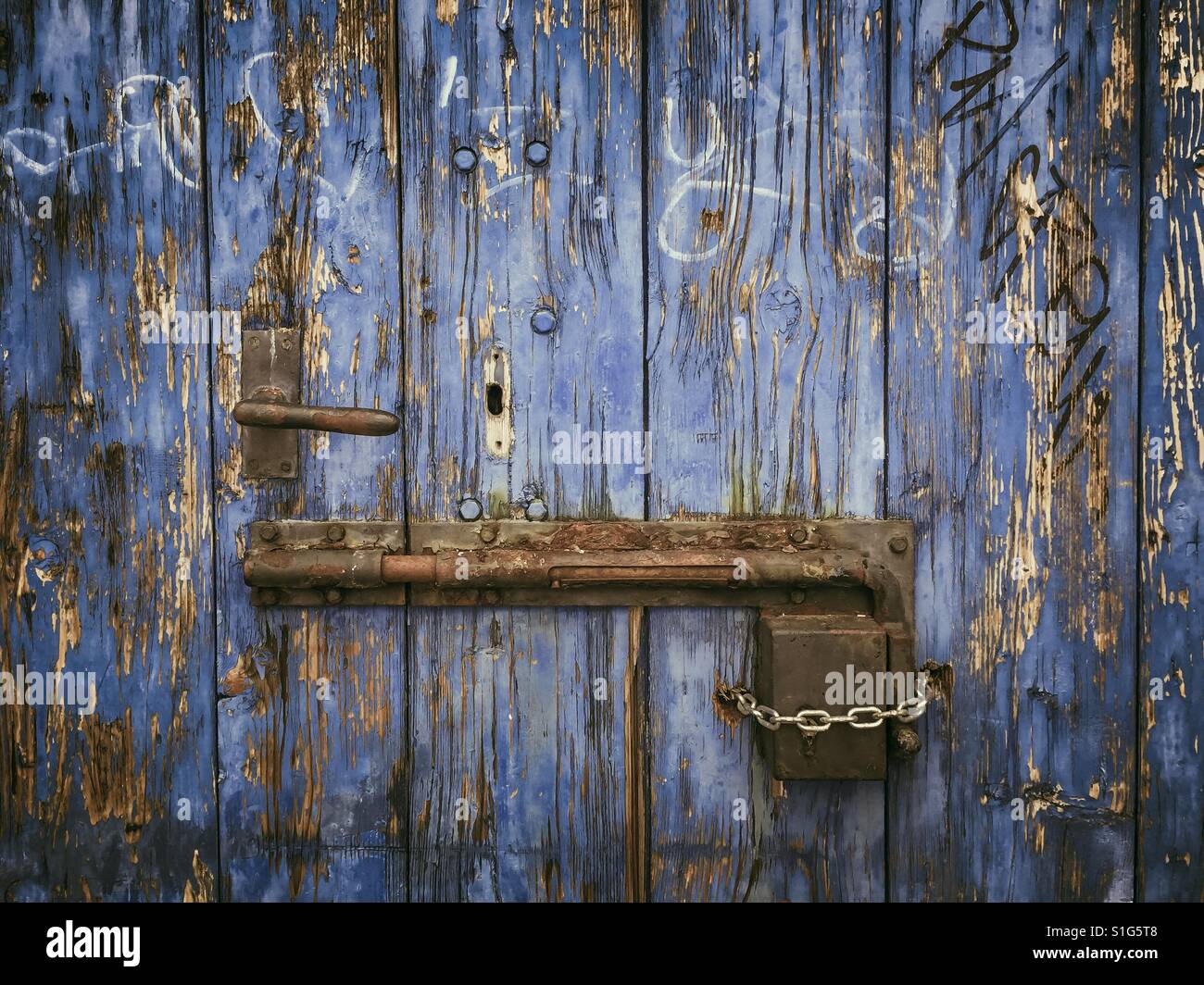 Rusty sliding door lock on weathered wooden blue door - Smartphone Captured Stock Image
