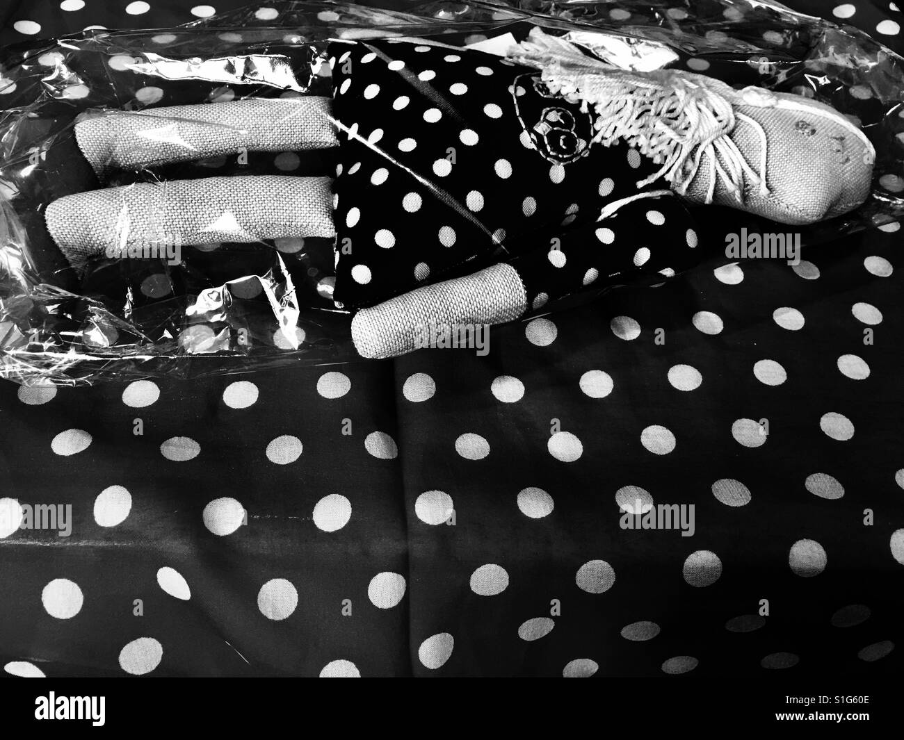 Unused Doll in an unopened plastic wrapper on polka dot background - Smartphone Captured Stock Image