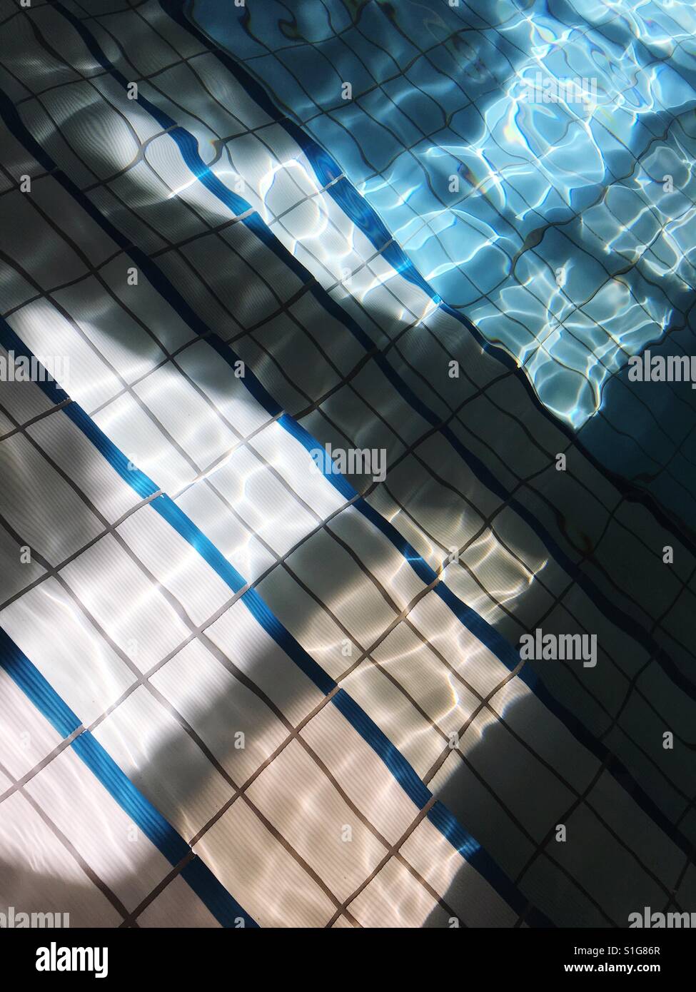 Light refractions on the steps of swimming pool Stock Photo