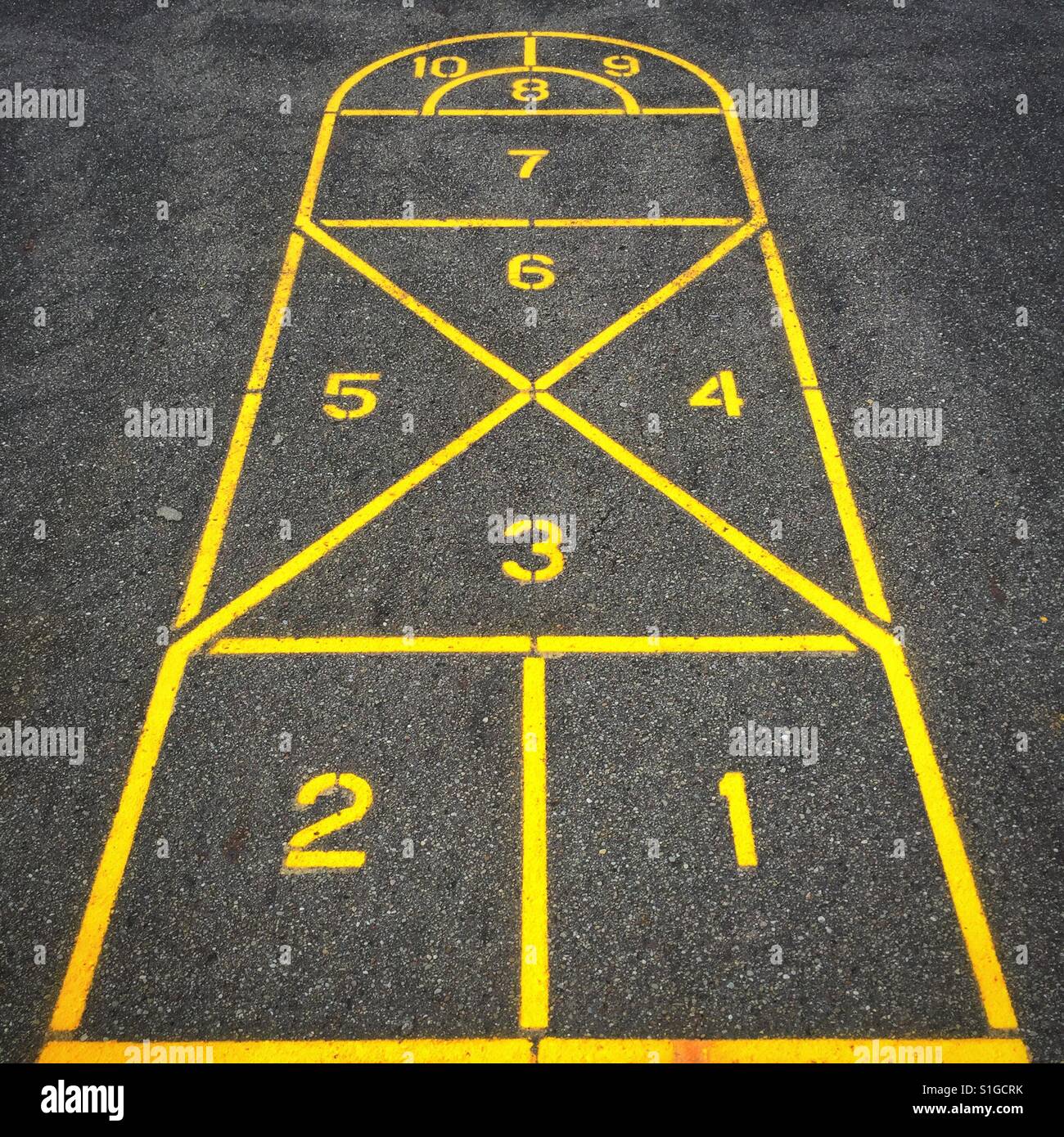 A hopscotch board painted in yellow on a cement playground Stock Photo ...
