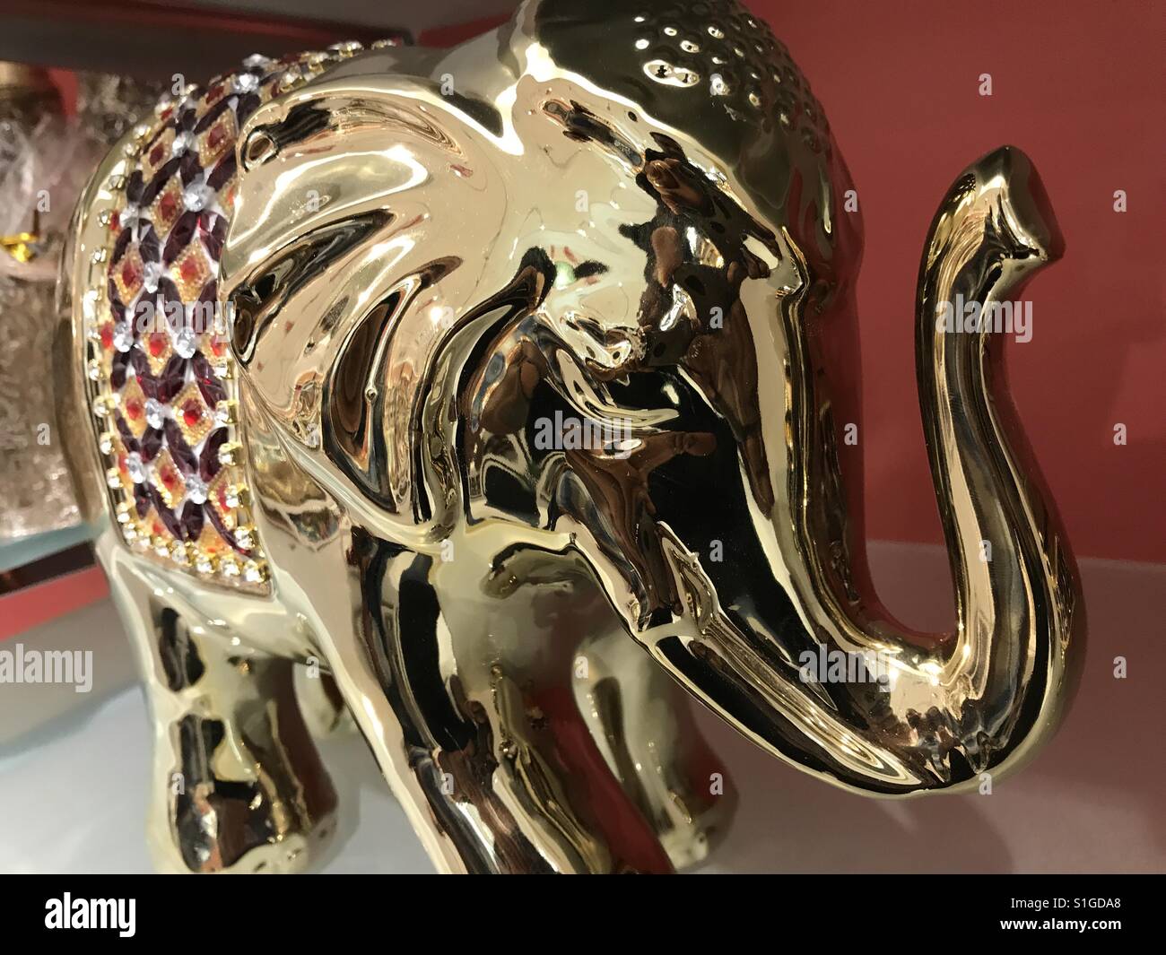 Elephant statue metal shine craft waves pattern trunk raise raised mammoth gold golden travel traveling bull tusk tuskers eyes large small Stock Photo