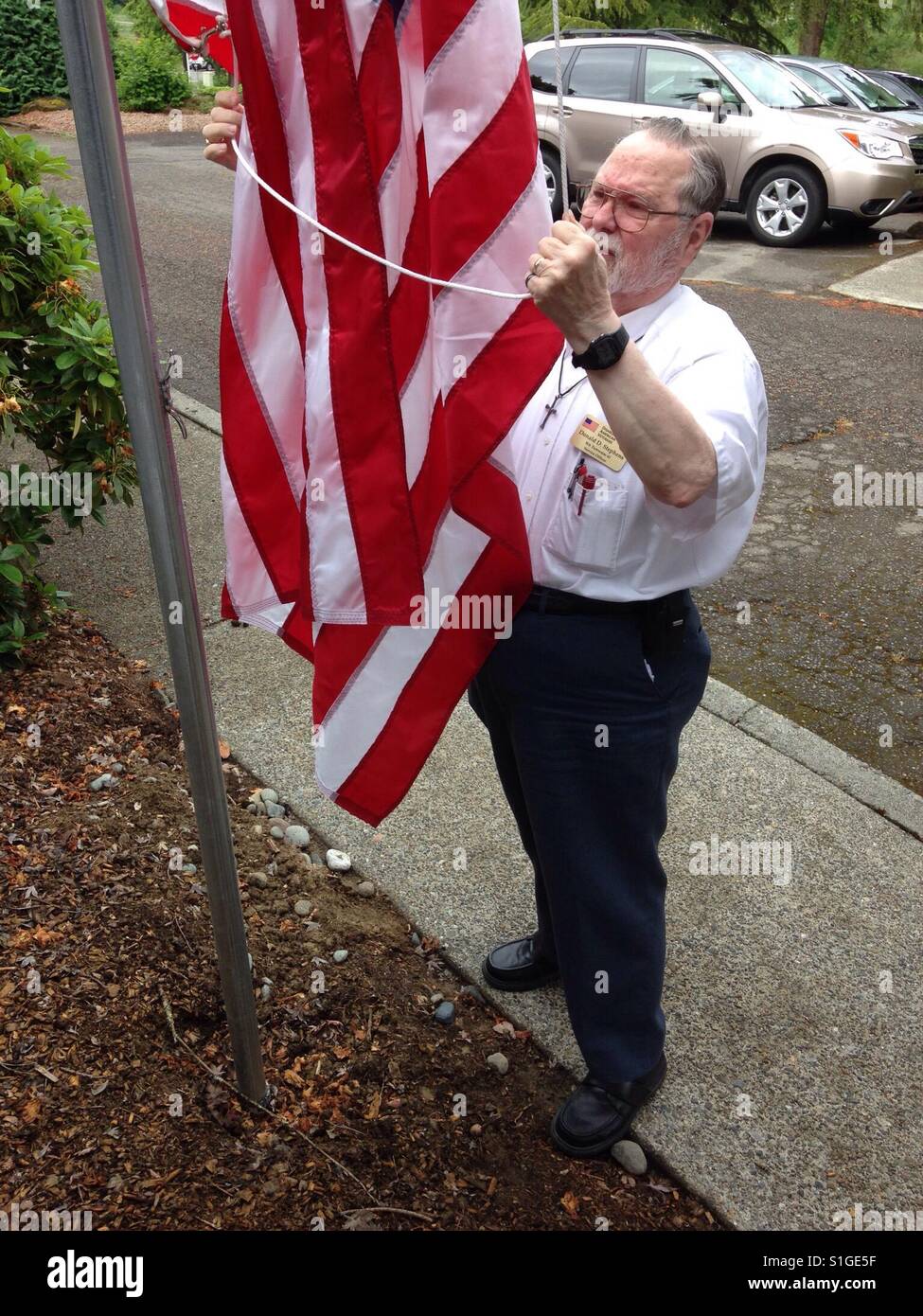 Veteran arranging the flag for raising Stock Photo