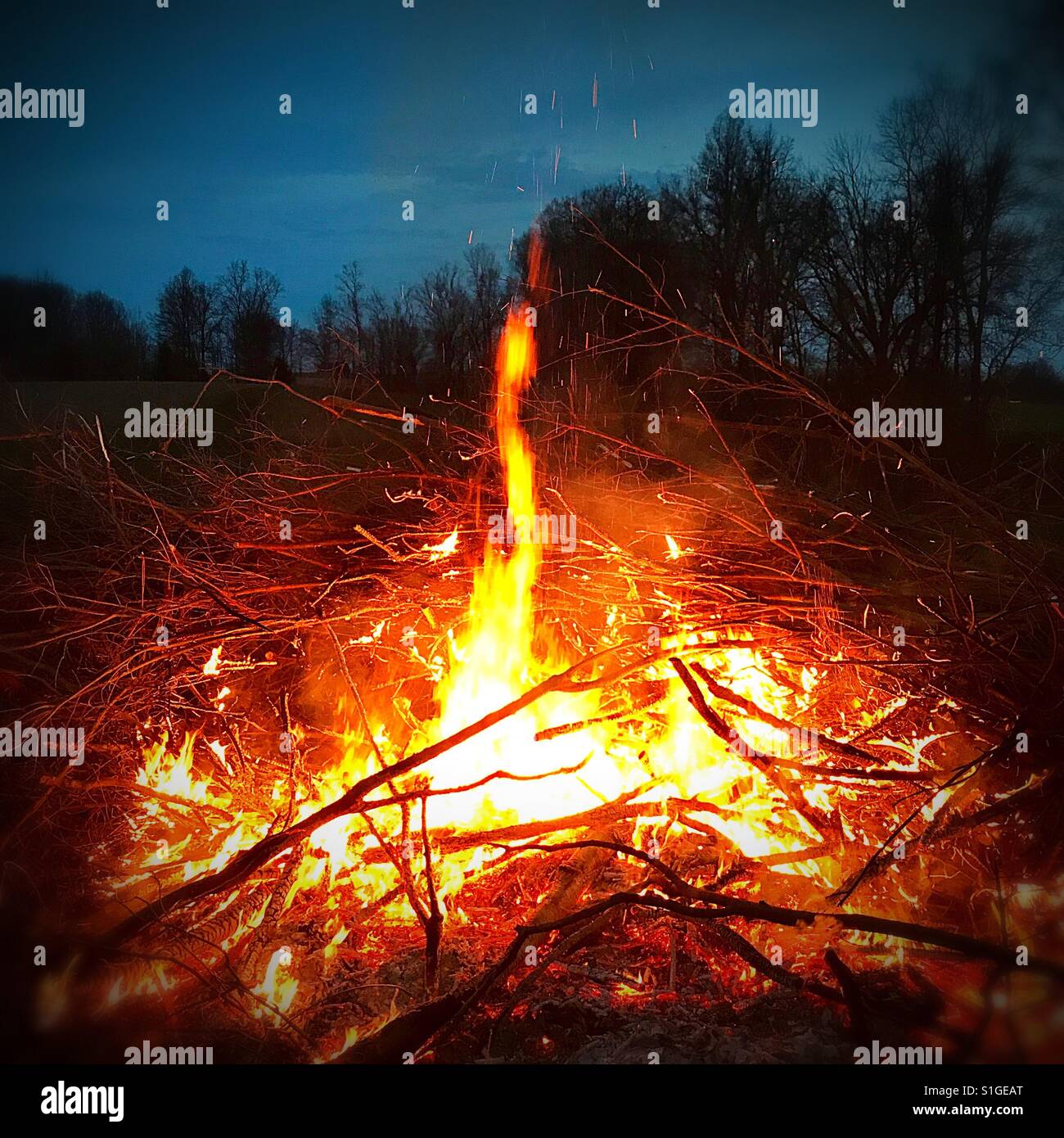 Campfire against a twilight sky Stock Photo