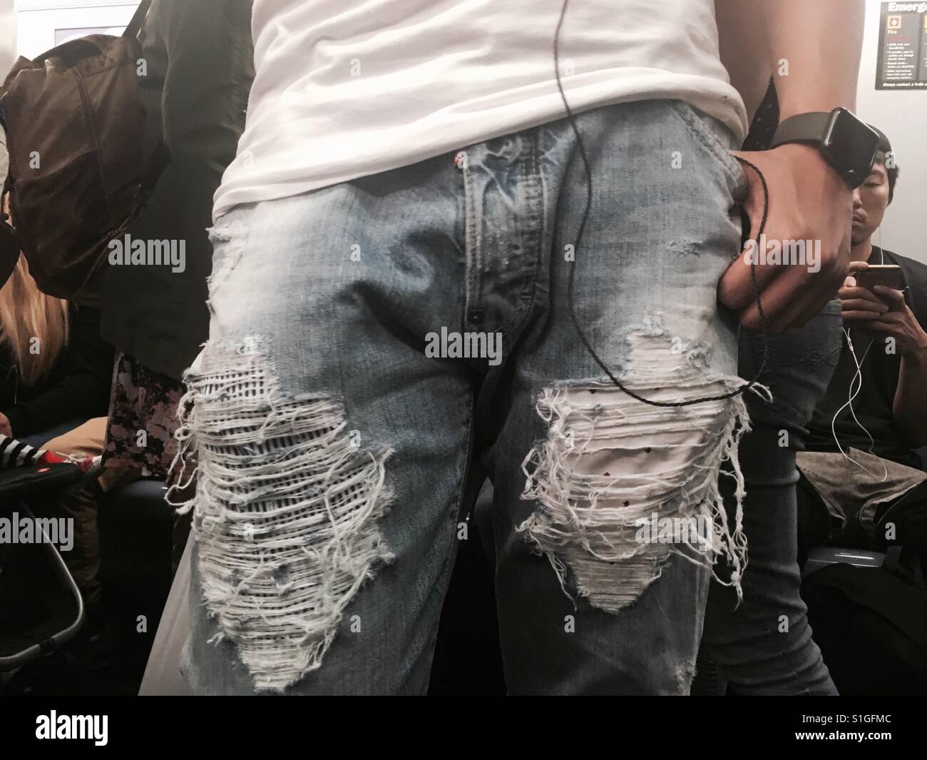 Man wears his fashion statement on his jeans riding the NYCity subway - Smartphone Captured Stock Image